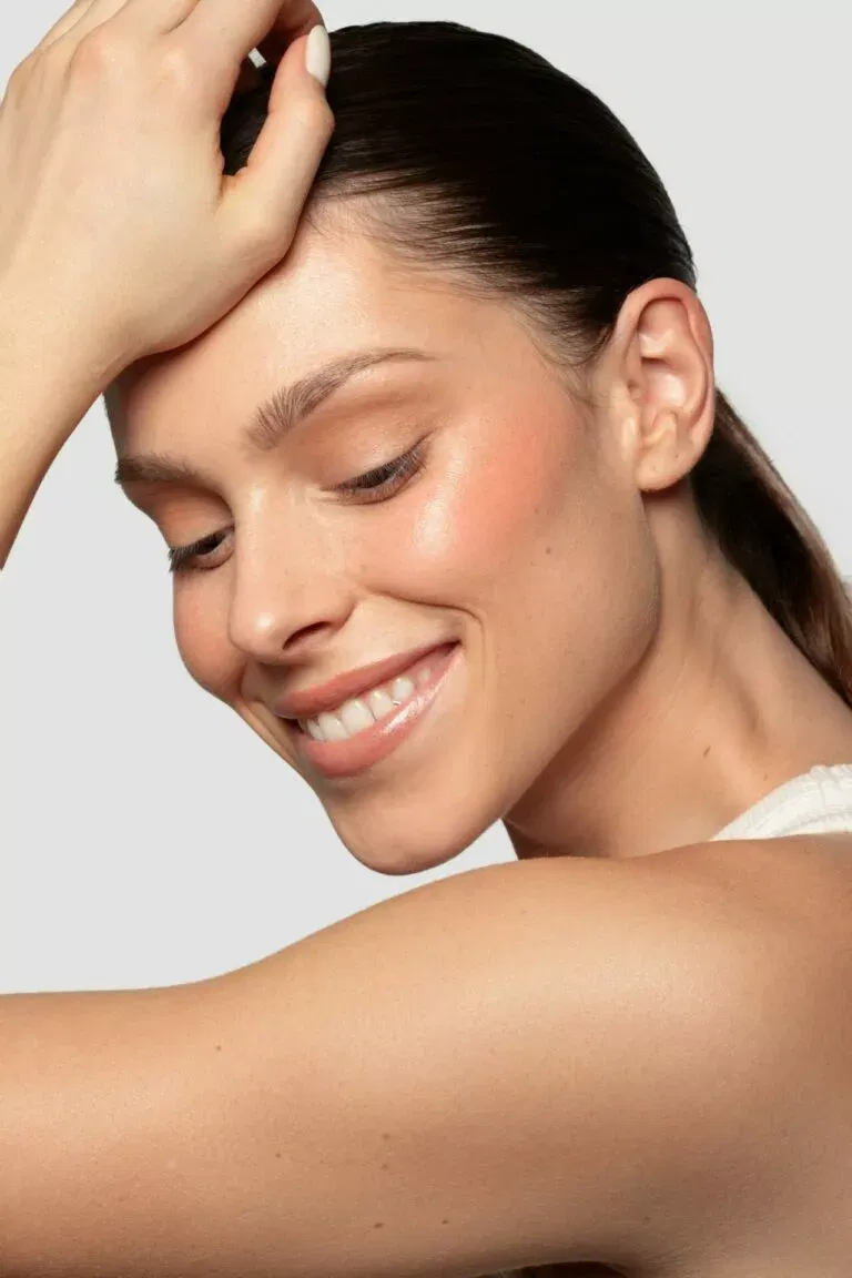 Femme à la peau rayonnante qui sourit après avoir réalisée un soin Hydrafacial adapté chez Maelis