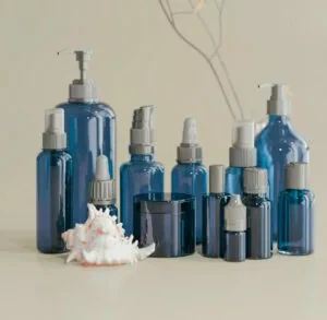 Ensemble de flacons bleus de soins cosmétiques détox, posés sur une surface claire, symbolisant une routine bien-être après les fêtes