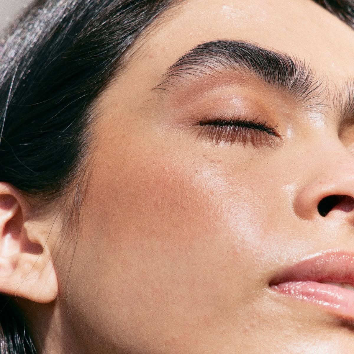 Visage d'une femme aux yeux fermés au soleil, mettant en avant des sourcils nets et parfaitement dessinés